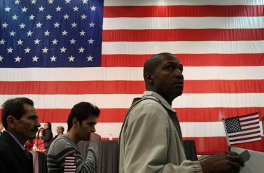 People carry flags as they arrive to receive U.S. citizenship at a naturalization ceremony in Los Angeles, California, on February 15th, 2017.